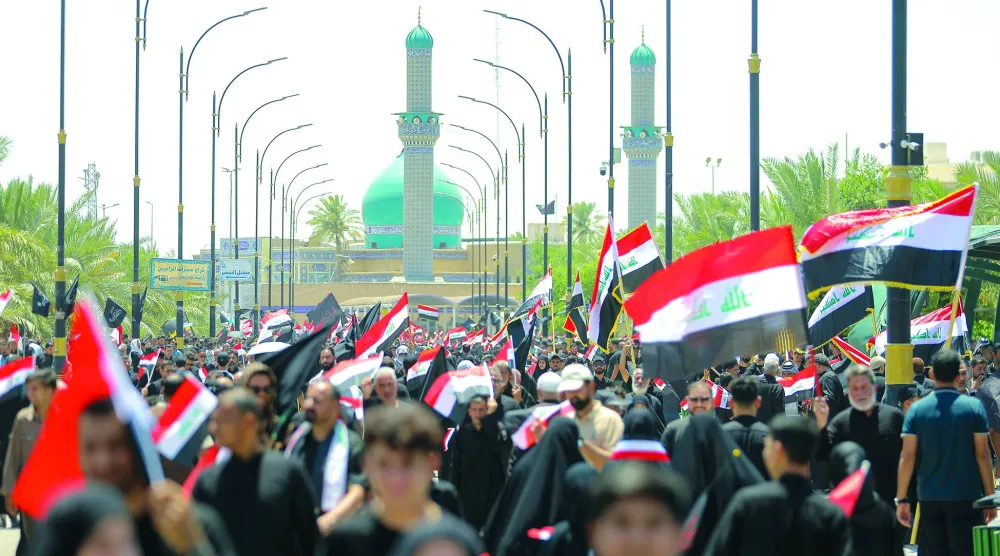أنصار مقتدى الصدر يلوّحون بالعلم العراقي خلال مظاهرة دعماً لإجراءات مكافحة الفساد في النجف (أ.ب)
