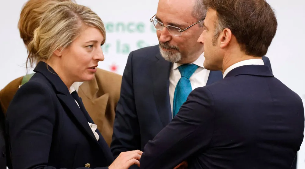 وزيرة الخارجية الكندية ميلاني جولي تتحدث مع الرئيس الفرنسي إيمانويل ماكرون في مؤتمر سوريا بباريس بحضور وزير الخارجية الأردني (رويترز)