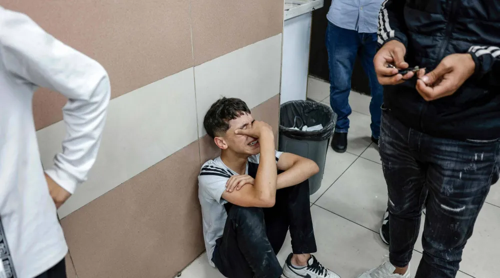 أحد أقارب الفتى وليد نضال وليد أبو سنينة الذي قتله الجيش الإسرائيلي يبكيه في مستشفى برام الله بالضفة الغربية (أ.ف.ب)