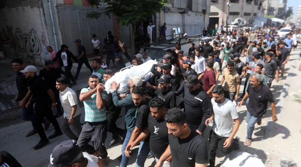 فلسطينيون يشيّعون يوم الاثنين جثماني محمد دغمش وزوجته اللذين قُتلا في غارة إسرائيلية استهدفت منزل عائلة دغمش بحي تل الهوى جنوب غربي مدينة غزة (د.ب.أ)