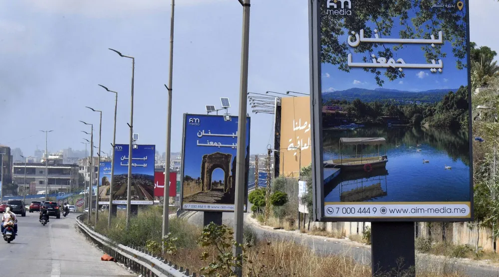 لوحات إعلانية تحمل عبارة «لبنان يجمعنا» رفعت على الطريق المؤدي إلى المطار في بيروت وذلك بعد بدء وقف إطلاق النار بين إسرائيل و«حزب الله» (إ.ب.أ)