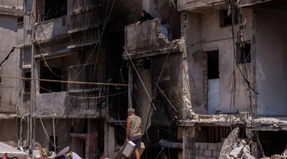 لبناني ينقل مواد بناء خلال ترميم منزله الذي تضرر جراء غارة إسرائيلية استهدفت مدينة صور في جنوب لبنان (رويترز)