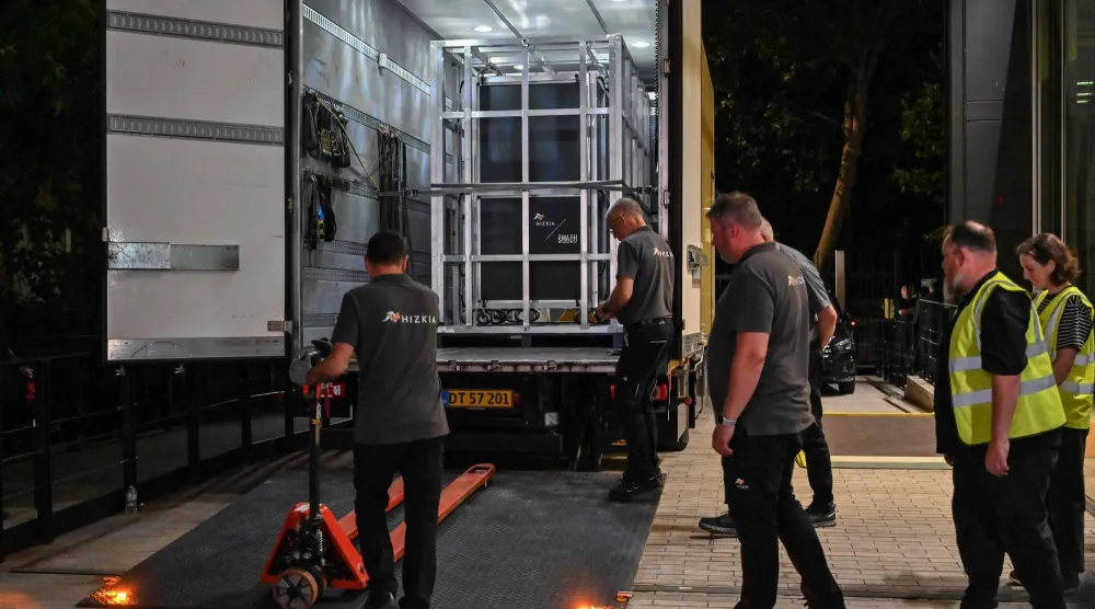 Workers prepare to unload a specially designed crate (back L) carrying the Bayeux Tapestry at the British Museum in central London early on July 10, 2026. (Photo by Richard A. Brooks / AFP)