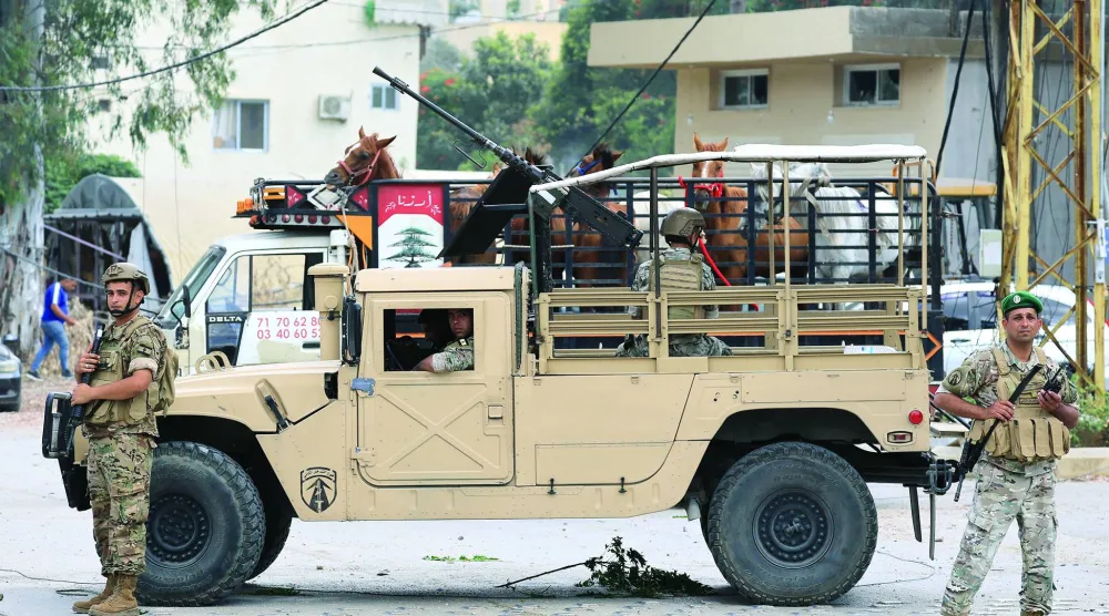 قوة من الجيش اللبناني تنتشر على مدخل بلدة زوطر الغربية المدرجة ضمن المنطقة التجريبية جنوب لبنان وتنتشر القوات الإسرائيلية على أطرافها (إ.ب.أ)