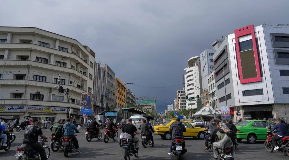 FILE - Motorbikes and cars pass through an intersection in downtown Tehran, Iran, May 17, 2026. (AP Photo/Vahid Salemi, File)