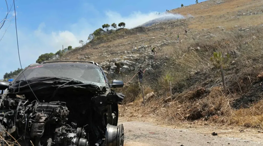 Lübnan'ın güneyindeki Kfar Rumman’da dün İsrail'in düzenlediği saldırıda tahrip olmuş bir araba (AFP)