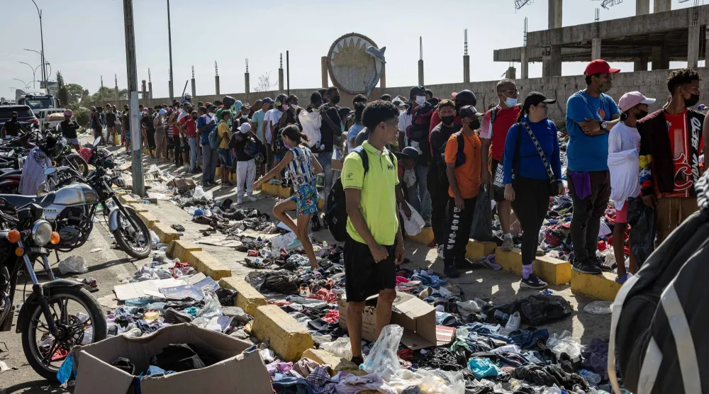 سكان يصطفون للحصول على مساعدات بعد الزلزال بمدينة لا غوايرا في فنزويلا (إ.ب.أ)