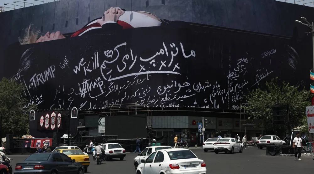  لوحة دعائية على مبنى في طهران تُظهر الرئيس الأميركي داخل نعش وعليها شعار بالفارسية نحن «نقتل ترمب» (رويترز)