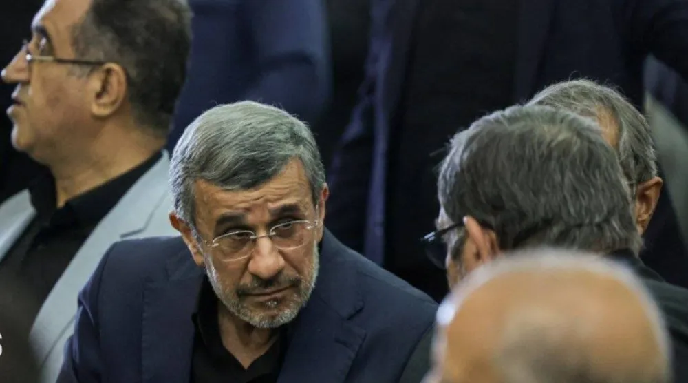 أحمدي نجاد يتحدث إلى أشخاص خلال مراسم تأبين المرشد السابق بحضور كبار المسؤولين الإيرانيين في طهران الثلاثاء(دولت بهار)