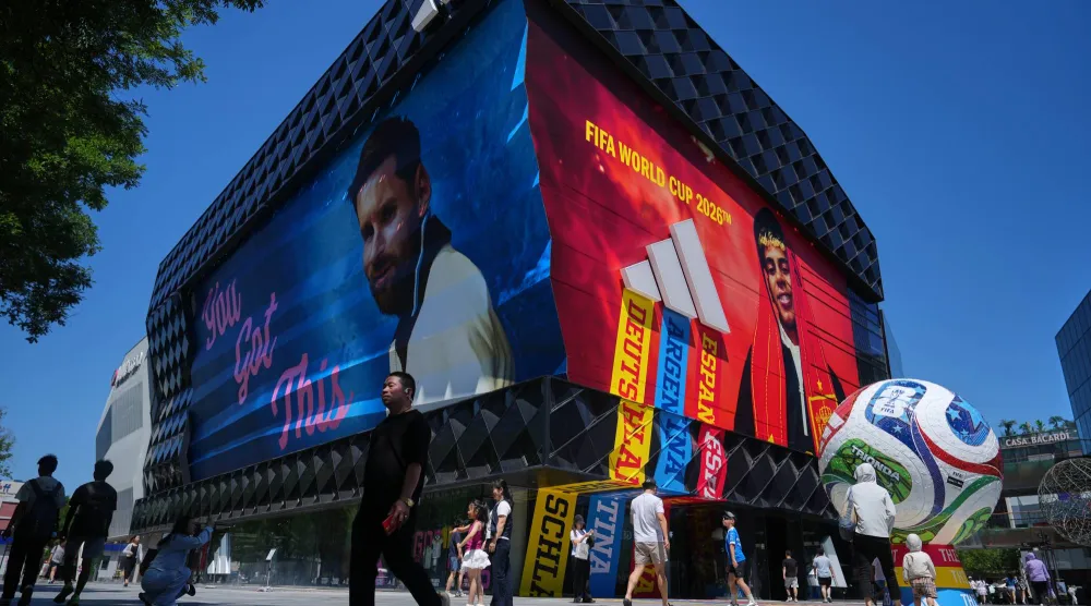 Shoppers walk by an Adidas sportswear store promoting the FIFA World Cup event at an outdoor shopping mall, in Beijing, Sunday, June 21, 2026. (AP Photo/Andy Wong)