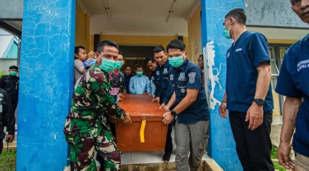 صورة أرشيفية تظهر جنوداً وشرطة إندونيسيين يحملون جثة شخص قُتل بانفجار ذخيرة (أ.ب)