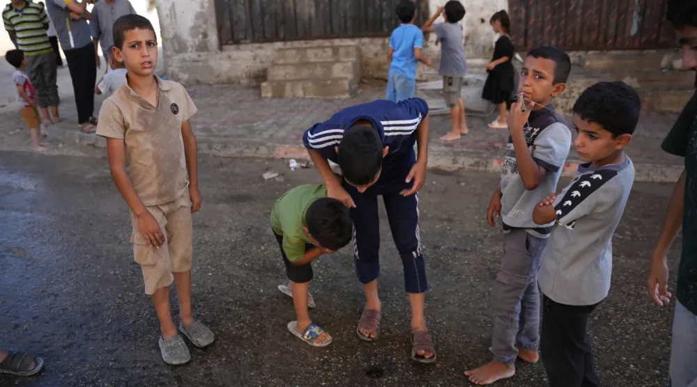 Gazze Şeridi'nin merkezindeki Nuseyrat mülteci kampında Filistinli çocuklar (AP)