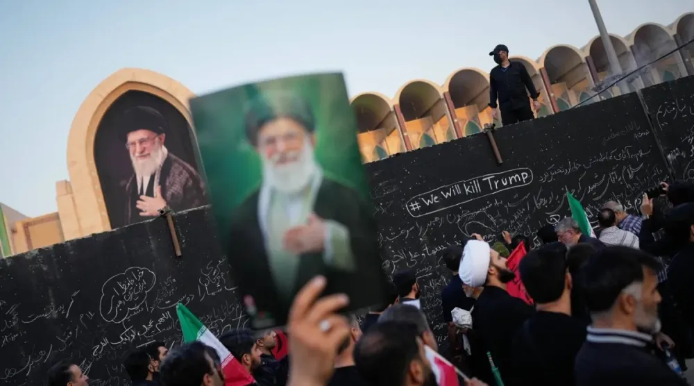 Tahran’daki cenaze töreninde Ali Hamaney’in fotoğrafını taşıyan bir İranlı (AP)