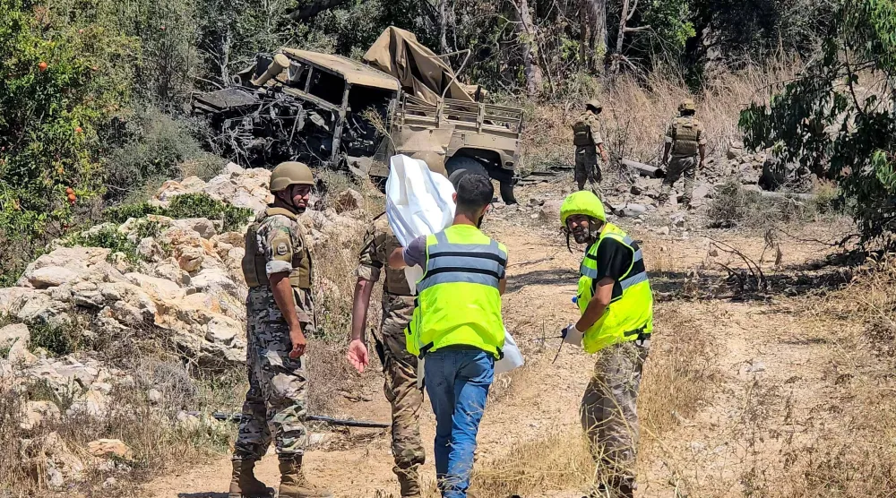 جنود من الجيش اللبناني يتفقدون موقع انفجار في منطقة المنصوري بجنوب لبنان حيث قتل عسكري وجرح اثنان آخران (أ.ف.ب)