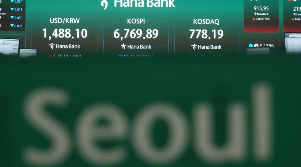 شاشات تعرض مؤشر «كوسبي» وسعر صرف العملات الأجنبية بين الدولار والوون الكوري الجنوبي في غرفة تداول بنك هانا بسيول (أ.ب)
