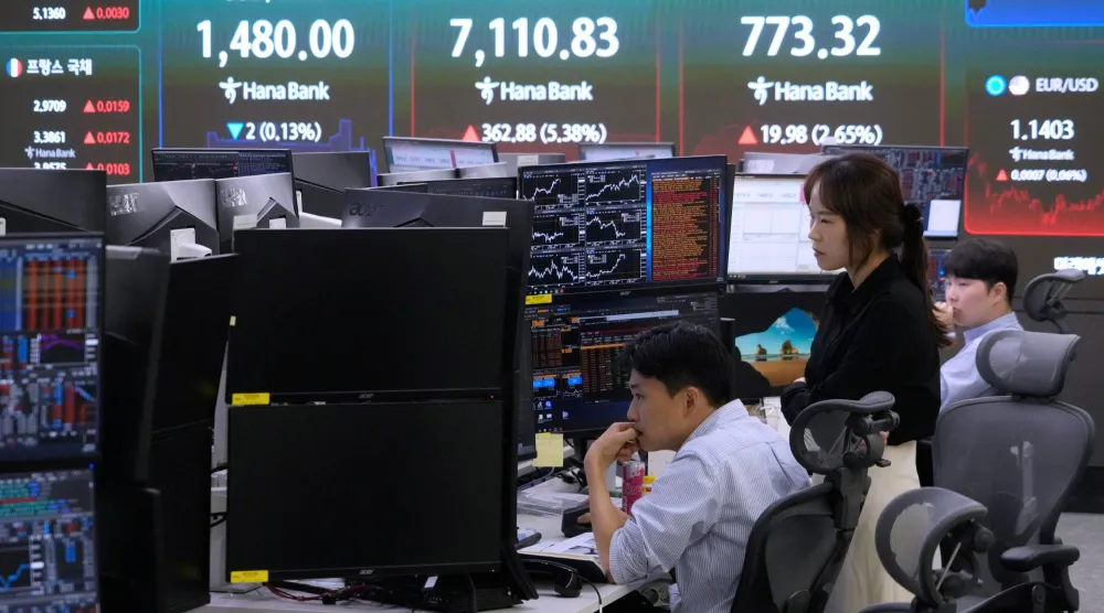 متداولون يراقبون مؤشر «كوسبي» وسعر صرف العملات الأجنبية بين الدولار والوون الكوري الجنوبي في بنك هانا بسيول (أ.ب)