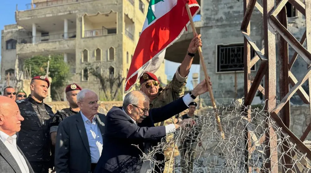 رئيس الحكومة اللبنانية نواف سلام يرفع العلم اللبناني خلال زيارة إلى بلدة زوطر الغربية بجنوب البلاد الأربعاء (أ.ب)