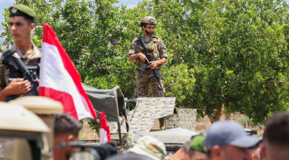 جنود لبنانيون على متن آليات عسكرية في مدخل بلدة زوطر الغربية التي انتشر الجيش فيها يوم الثلاثاء بعد انسحاب إسرائيلي (رويترز)