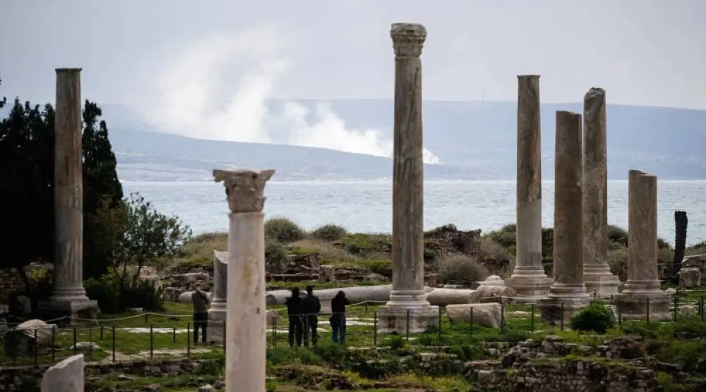 صورة التُقطت في 23 مارس 2026 تظهر دخاناً يتصاعد من موقع غارة جوية إسرائيلية خلف الموقع الأثري لآثار الميناء الفينيقي في مدينة صور جنوب لبنان (أ.ف.ب)