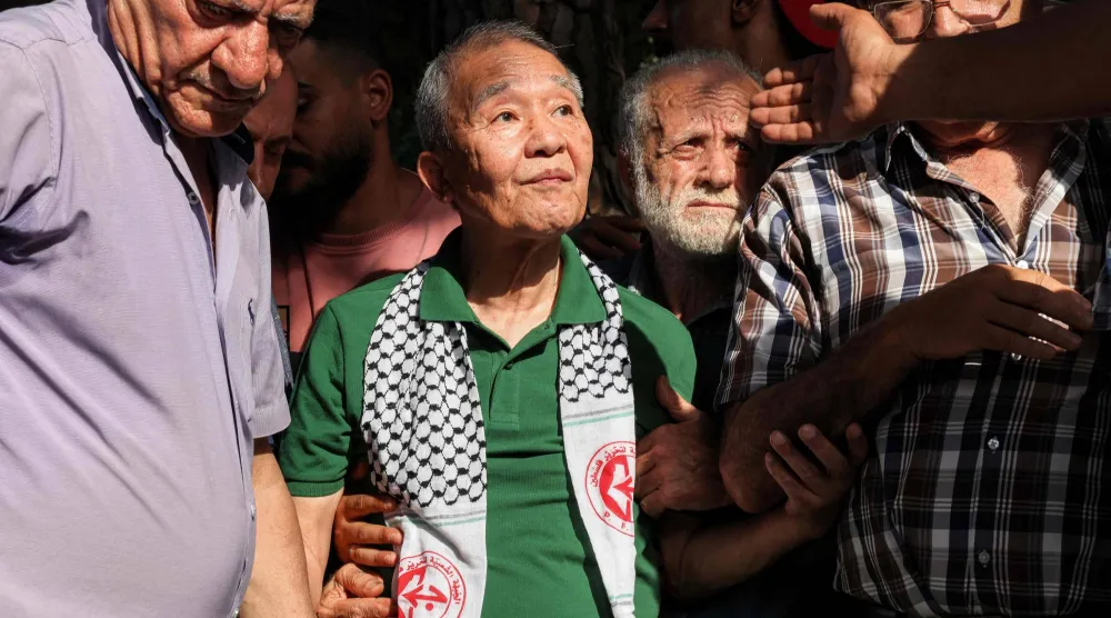 كوزو أوكاموتو (في الوسط) العضو الوحيد الباقي على قيد الحياة من وحدة الكوماندوز المكونة من ثلاثة رجال «الجيش الأحمر الياباني» التي قتلت 26 شخصاً في هجوم على مطار اللد الإسرائيلي يوم 30 مايو 1972 يحضر حفلاً نظّمه مسلحون فلسطينيون لإحياء الذكرى الخمسين لهجوم اللد في إسرائيل... بيروت 30 مايو 2022 (أ.ف.ب)