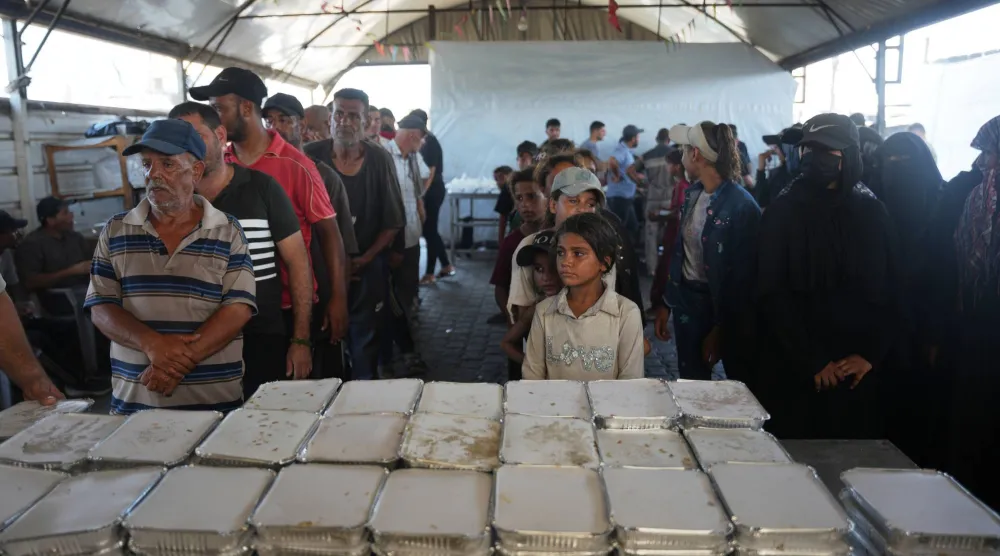 نازحون فلسطينيون ينتظرون الحصول على حصتهم من الطعام لدى مطعم جمعية في خان يونس جنوب غزة (أ.ب)
