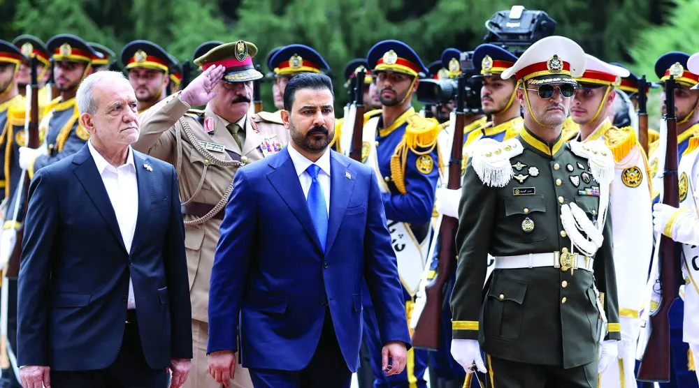 رئيس الوزراء العراقي علي الزيدي (وسط) يستعرض مع الرئيس الإيراني مسعود بزشكيان حرس الشرف (الرئاسة الإيرانية)