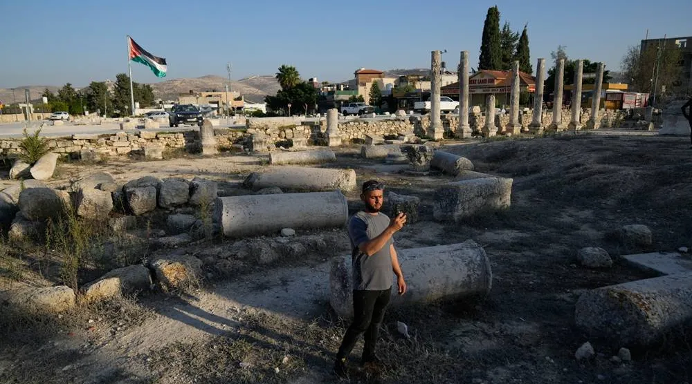 A Palestinian visitor takes a photo at the Roman historical site in the West Bank town of Sebastia, Thursday, Nov. 20, 2025. (AP)