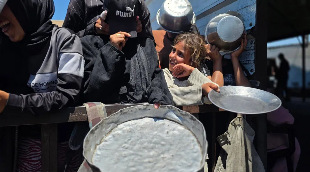 فلسطينيات في قطاع غزة يقفن في طابور للحصول على مساعدات غذائية (د.ب.أ)