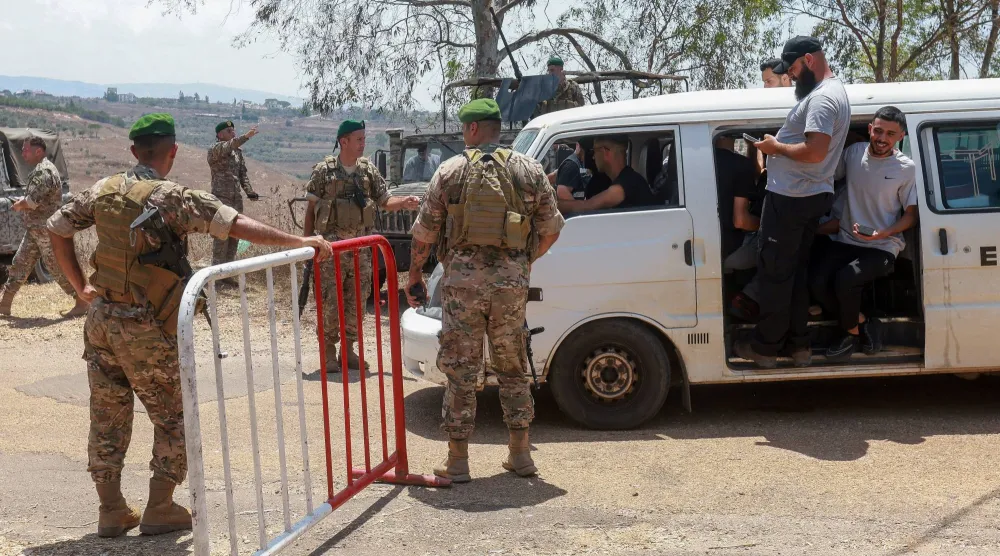 جنود لبنانيون يفتشون إحدى السيارات قبل الدخول إلى بلدة زوطر الغربية في جنوب لبنان بعد انسحاب القوات الإسرائيلية منها (رويترز)