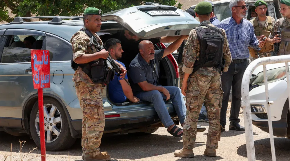 جنود لبنانيون يفتشون سيارة قبل دخولها بلدة زوطر الغربية المدرجة ضمن المناطق النموذجية في جنوب لبنان (رويترز)