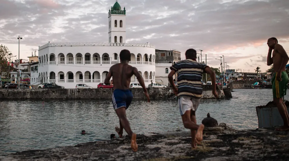  Children jump in the ocean in the former dhow port of Kalaweni, opposite the Grand Mosque, in Moroni's historic Medina on July 17, 2026. (AFP) 