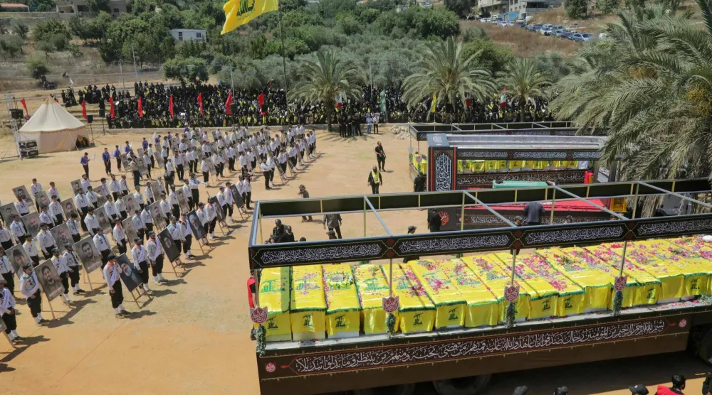 نعوش عناصر «حزب الله» الذين قُتلوا خلال اشتباكات مع الجيش الإسرائيلي إلى جانب نعش رمزي للمرشد الإيراني السابق علي خامنئي... وذلك في أثناء جنازة جماعية بقرية مجدل سلم بجنوب لبنان يوم 18 يوليو 2026 (أ.ف.ب)