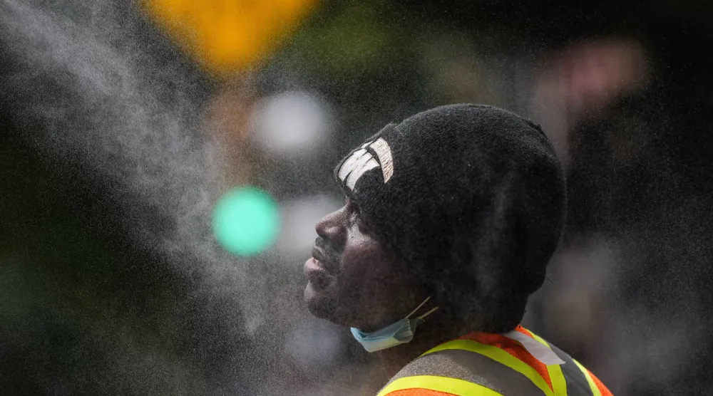 A man cools off at a misting station in the Downtown Eastside of Vancouver, British Columbia, Canada, on Wednesday, July 22, 2026. (Darryl Dyck/The Canadian Press via AP)