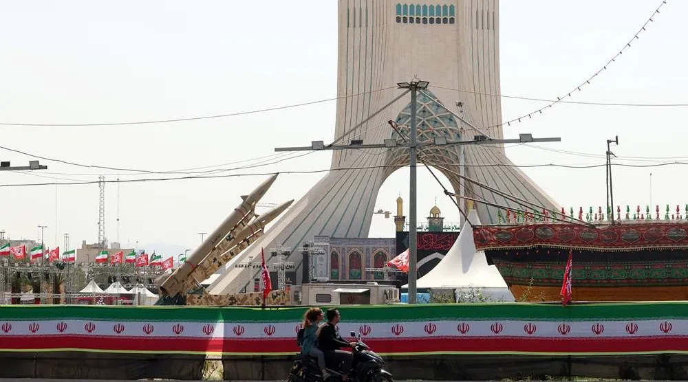 An Iranian couple rides a motorbike next to Iranian missiles, Zolfaghar, on display at Azadi Square in Tehran, Iran, 24 July 2026. (EPA)