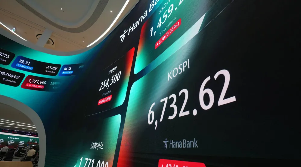 شاشات تعرض مؤشر «كوسبي» وسعر صرف الدولار الأميركي مقابل الوون داخل قاعة التداول ببنك هانا (أ.ب)