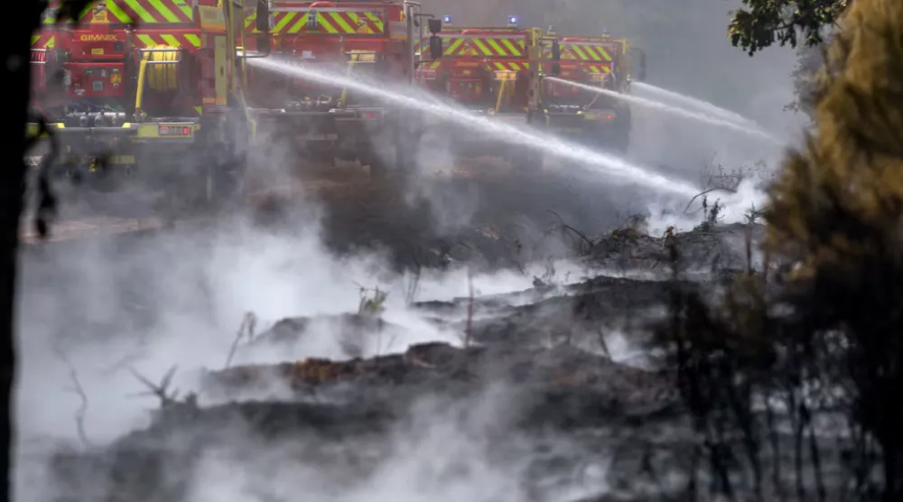 Firefighters work to battle wildfires amid drought conditions following a heatwave and water shortages across much of France, in Marcheprime, Gironde department, France, July 27, 2026. REUTERS