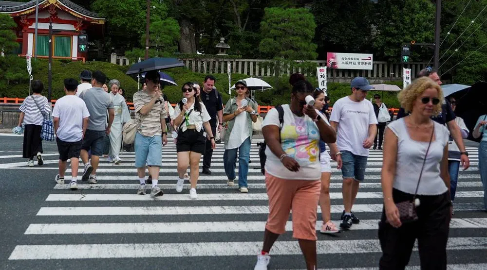  People use portable fans to cool themselves on the street as the Japanese government issued a heatstroke alert in Tokyo and other prefectures due to a heatwave, in Kyoto, western Japan July 23, 2026. (Reuters)