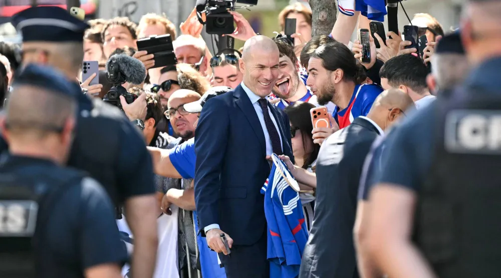 French international football player Zinedine Zidane poses for selfies with fans as he leaves after a press conference to present him as the new head coach of France national football team at the French Football Federation headquarters (FFF) in Paris on July 28, 2026. (AFP)