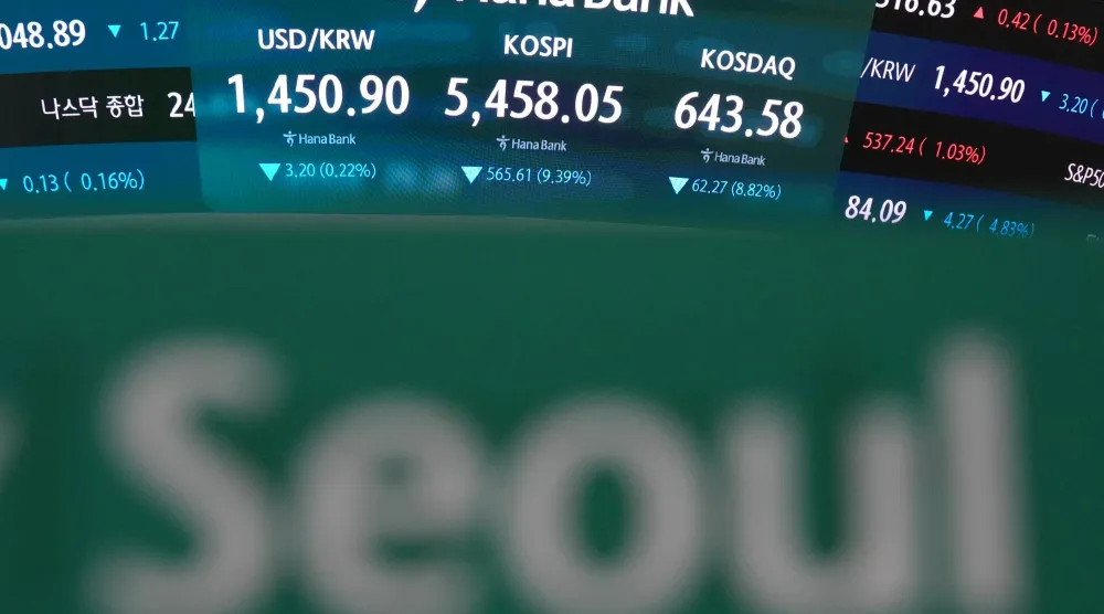 شاشات تعرض مؤشر «كوسبي» وسعر صرف الدولار الأميركي مقابل الوون الكوري الجنوبي في قاعة التداول التابعة لبنك هانا في سيول (أ.ب)