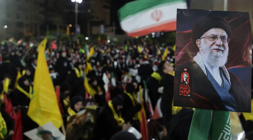 مناصرون لـ«حزب الله» يرفعون علمي الحزب وإيران في ضاحية بيروت الجنوبية خلال مراسم تشييع المرشد الإيراني السابق علي خامنئي (إ.ب.أ)