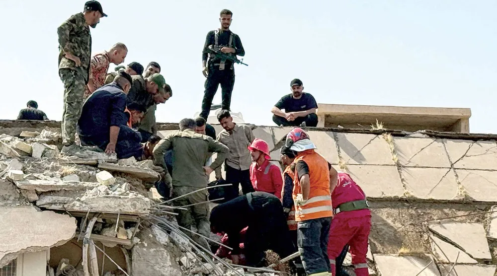  عناصر من الأمن والدفاع المدني يعملون في موقع غارة شمال مدينة المقدادية بمحافظة ديالى العراقية أمس (أ.ف.ب)