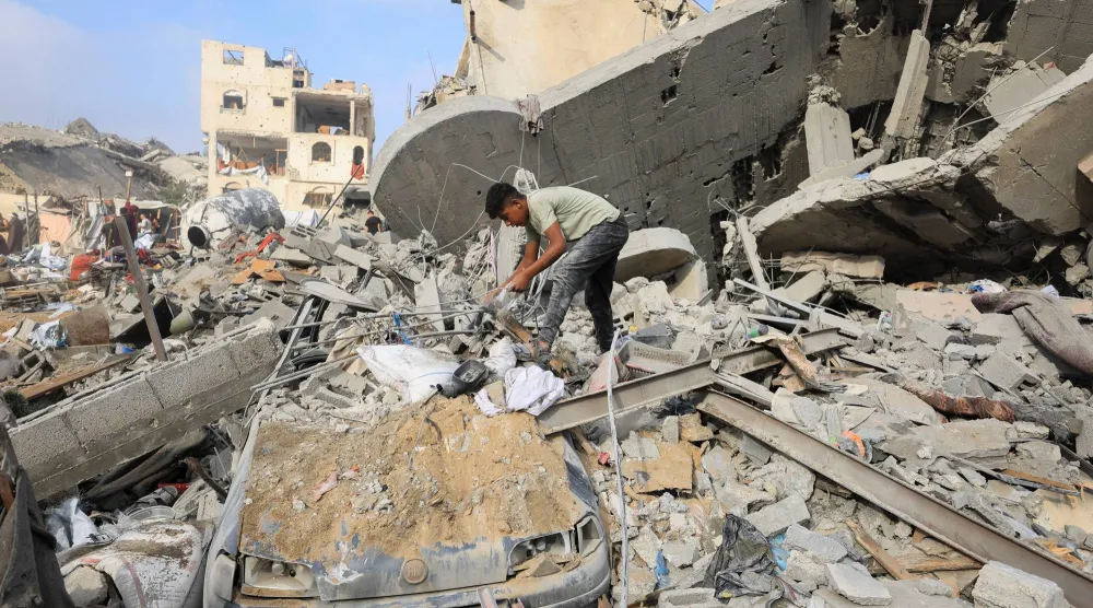 طفل فلسطيني يتفقد موقع الغارة الإسرائيلية التي استهدفت مدينة غزة (رويترز)