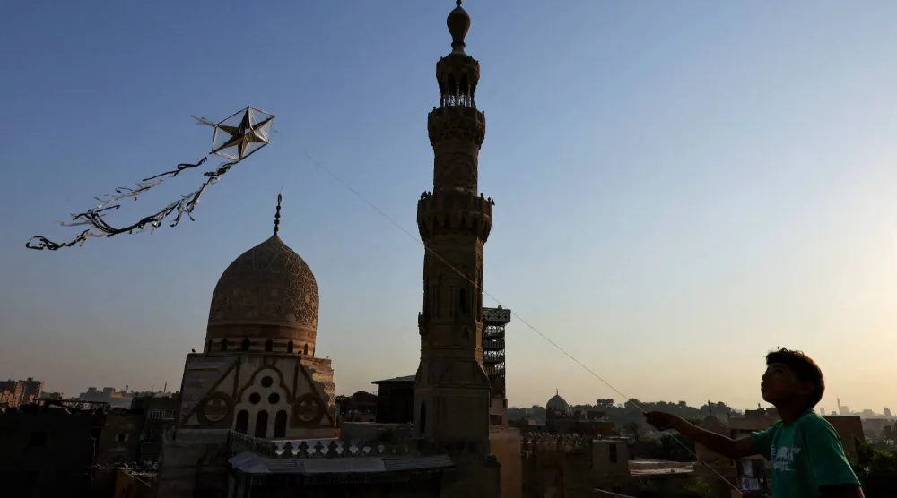 طفل يلهو بطائرة ورقية أمام مسجد السلطان قايتباي في وسط العاصمة المصرية القاهرة (رويترز)