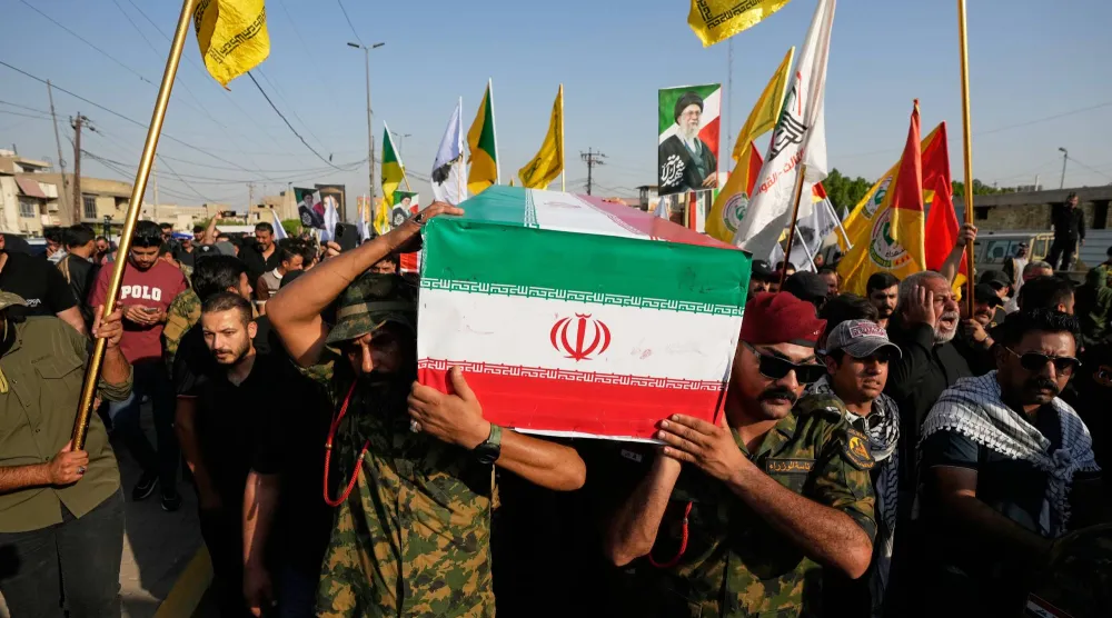 مشيّعون يحملون جثمان أحد المستشارين الإيرانيين الذين قُتلوا في العراق (أ.ب)