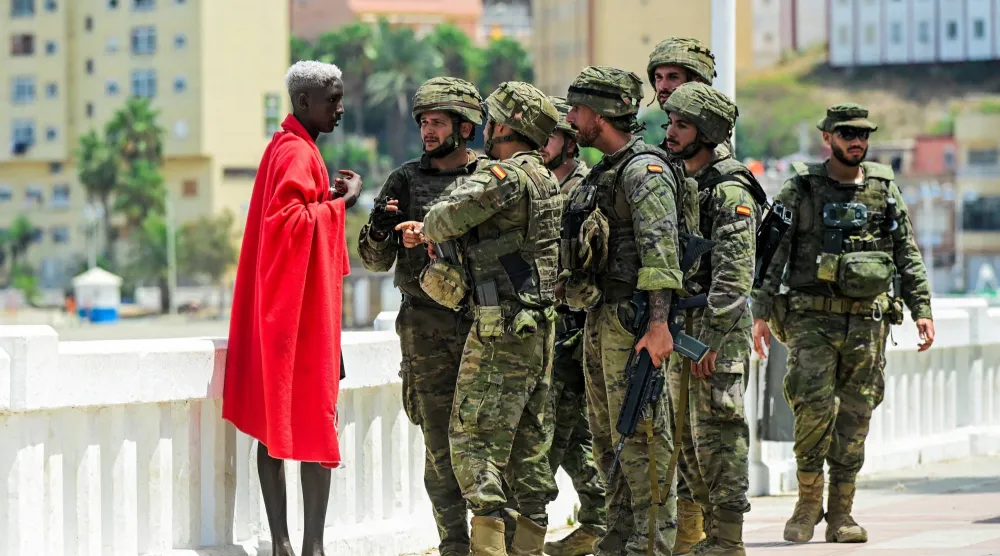 عناصر الشرطة الإسبانية خلال توقيف مهاجر سري في سبتة (رويترز)