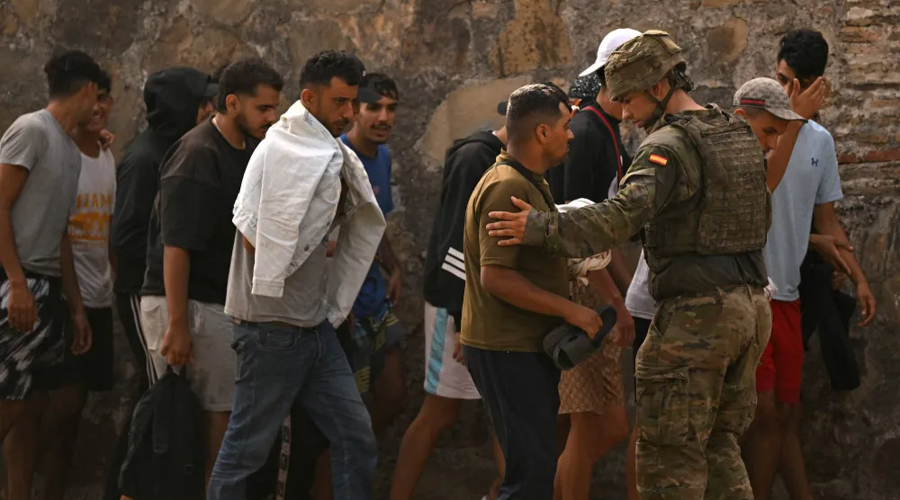شرطي إسباني يشارك في عملية تنظيم العودة الطوعية لآلاف المهاجرين من سبتة إلى الأراضي المغربية (أ.ف.ب)
