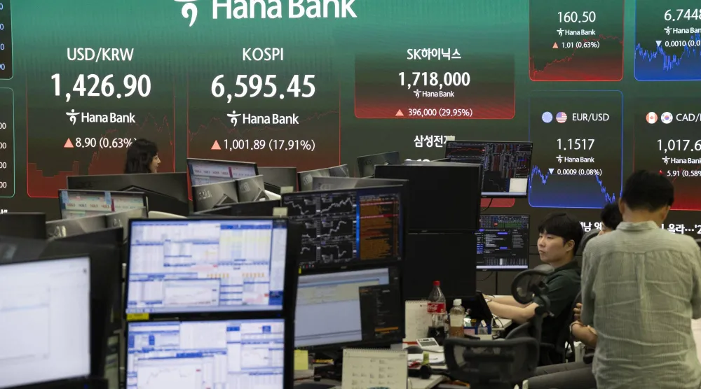 يعمل متداولون كوريون جنوبيون أمام شاشات التداول ببنك هانا في سيول (إ.ب.أ)
