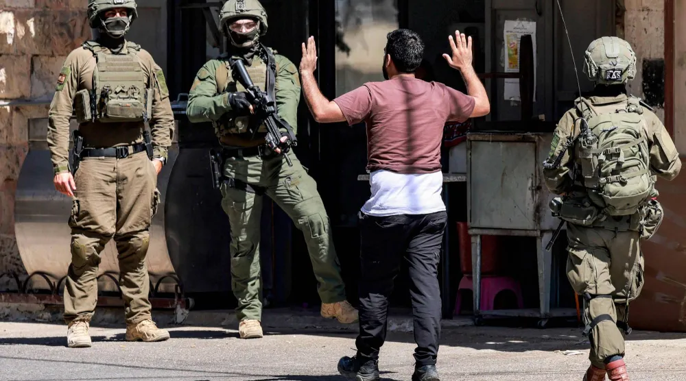 جنود إسرائيليون خلال العملية العسكرية المتواصلة في نابلس بالضفة الغربية المحتلة يطلبون من فلسطيني الاقتراب رافعاً يديه (أ.ف.ب)