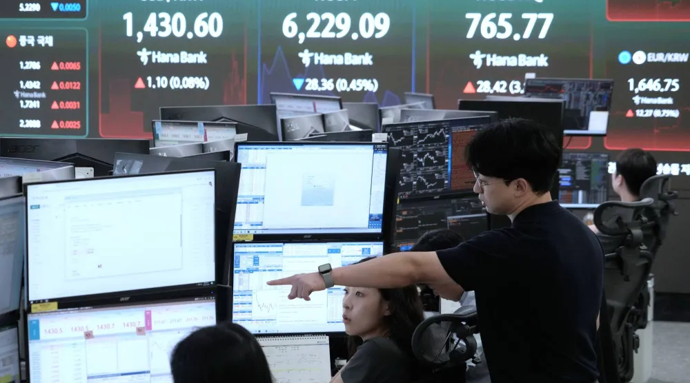 متعاملون يراقبون شاشات تعرض مؤشر «كوسبي» وسعر صرف الدولار مقابل الوون في قاعة تداول العملات الأجنبية ببنك هانا في سيول (أ.ب)