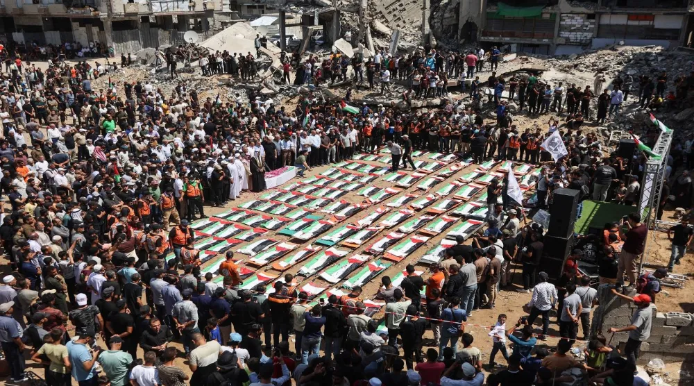 Gazze'deki enkazın altından çıkarılan 112 Filistinlinin cenaze törenindeki Filistinliler (AFP)